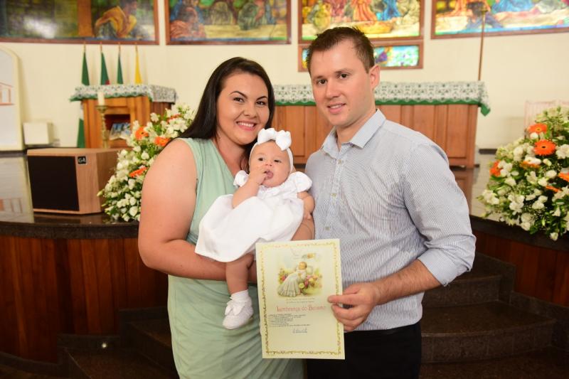Pâmela e Adriano com a filha Manuela, durante seu batizado na Igreja Matriz
