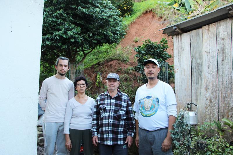Christian com os avós Lúcia e Fermino, ao lado do vizinho Adão. Barranco fica bem atrás da casa deles