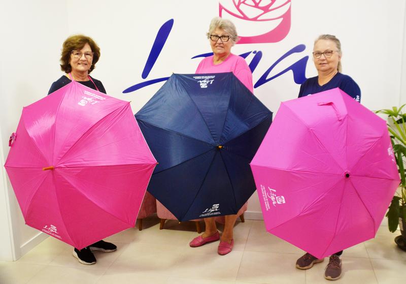 Voluntárias Alice, Carmen e Ângela com os guarda-chuvas e sombrinha lançadas pela Liga