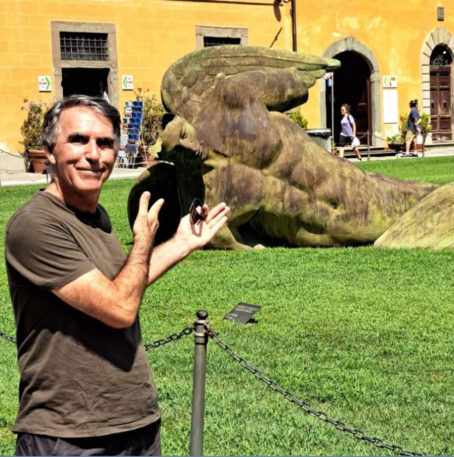 O anjo caído, a chocante e linda obra do escultor Igor Mitoraj, ao lado da torre em Pisa