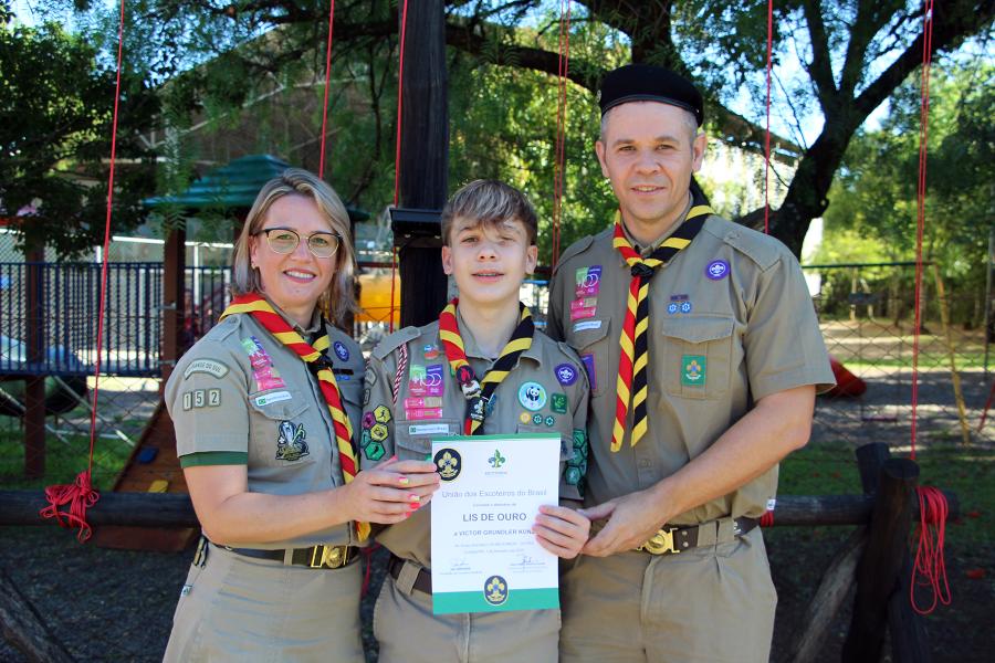 Victor Grundler Kunz recebeu a honraria Lis de Ouro ao lado dos pais Michele e Leandro